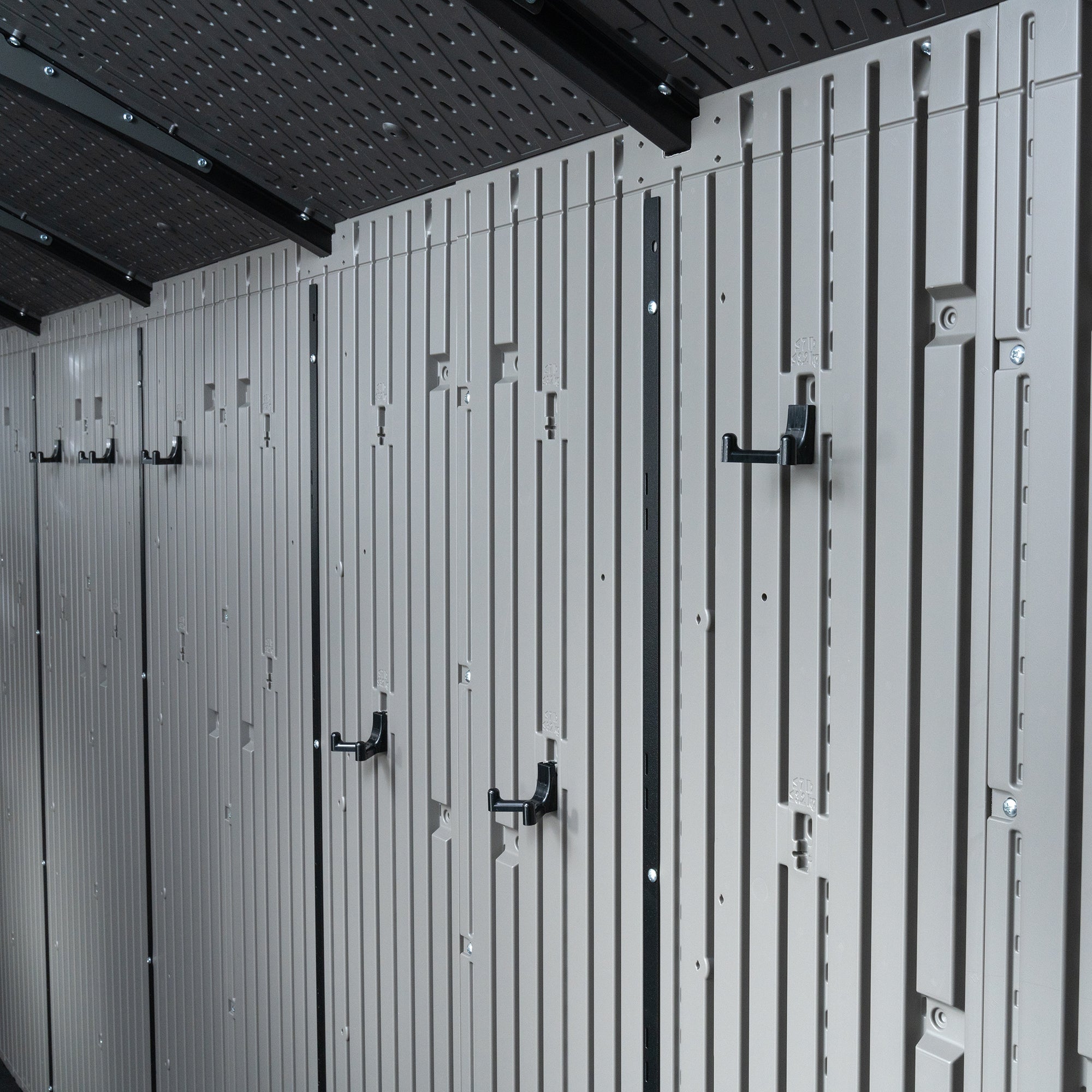 Interior of a Lifetime 20x8 shed with multiple hooks and brackets mounted on the wall for storage. 